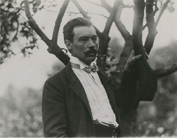 Portrets. Janis Rozentāls pie koka, nepilnā augumā, puspagriezienā. [Ap 1910. gadu?]. Foto nezināms. Kopija. [1970-1980?]